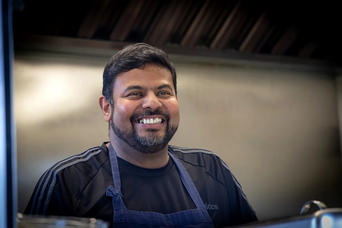 Close-up portrait of Shanil smiling in the kitchen